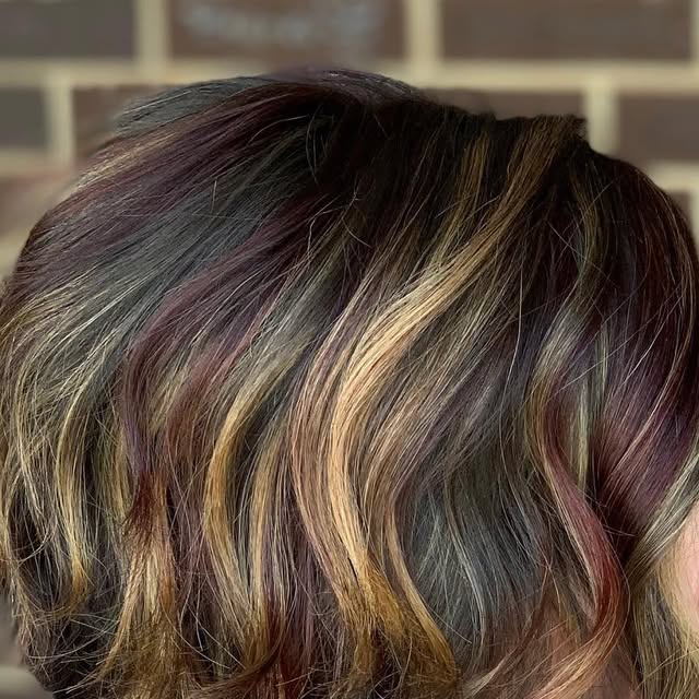 A shaped shoulder-length bob with warm auburn and caramel tones.