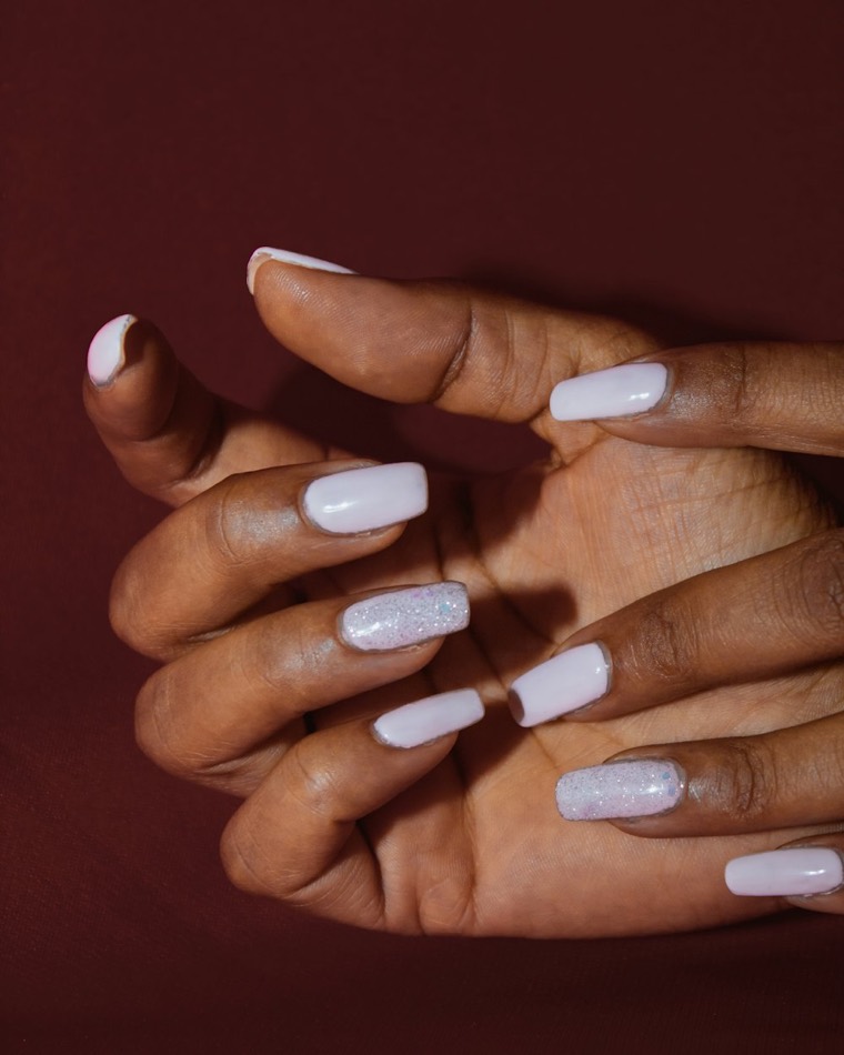 Hands with pale lilac square-shaped nails finished with silver glitter accent nails.